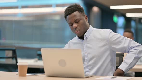 African Businessman with Laptop Having Back Pain