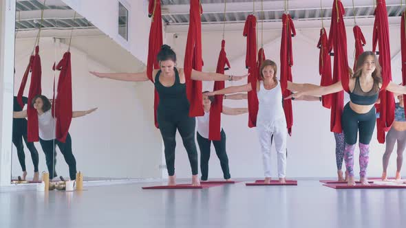 Slim Ladies Group Enjoys Practicing Anti-gravity Yoga Asana