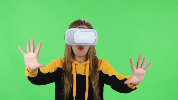 Portrait of Modern Girl in Yellow Hoodie with Virtual Reality Headset or 3d Glasses. Green Screen