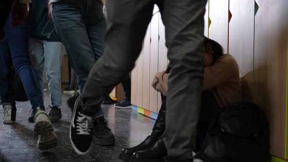 Upset Asian Schoolgirl Sitting on Floor at School