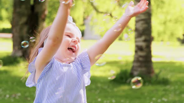 Little Girl Playing with Soap Bubbles at Park