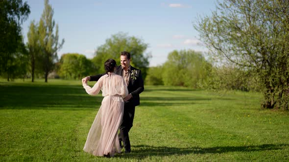 Carefree Woman and Man are Walking in Fabulous Garden Loving Couple is Enjoying Walk and Having Fun