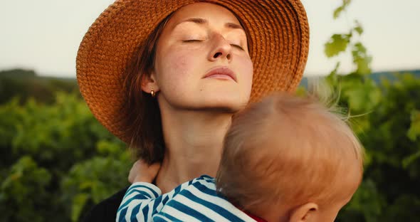 Portrait of Young Mother Gently Hugging Her Cute Little Baby Son in French Provence Vineyard During