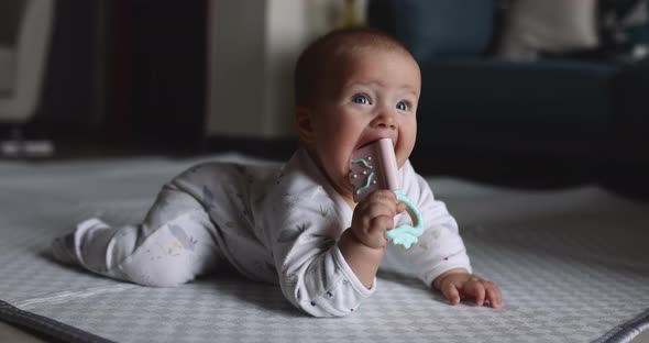 Authentic Close Up Cute Caucasian Baby Girl 67 Months Old Playing with Plastic Toy on Floor in