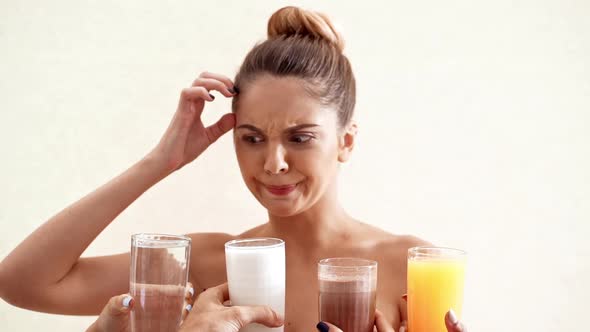 Hands Offering Different Drinks to Young Beautiful Naked Girl in Towel Over White Background