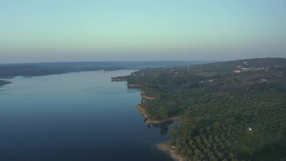 Aerial View Over A Mountain Dam With Fog in the background Before Sunrise