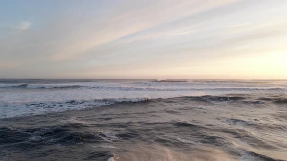 Drone Over Waves Towards Horizon At Sunset