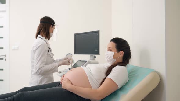 Doctor in Mask and Gloves Checking Woman with Ultrasound