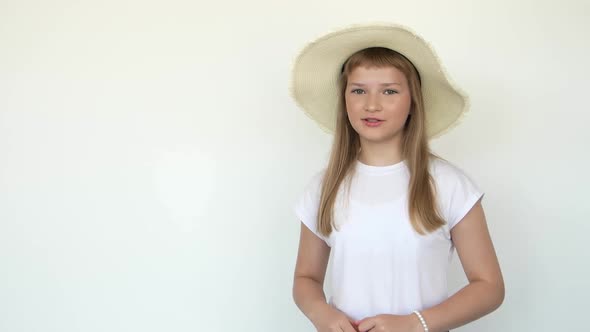 Calm Little Girl Standing in Swimming Wear and Panama Hat Isolated Over White Background