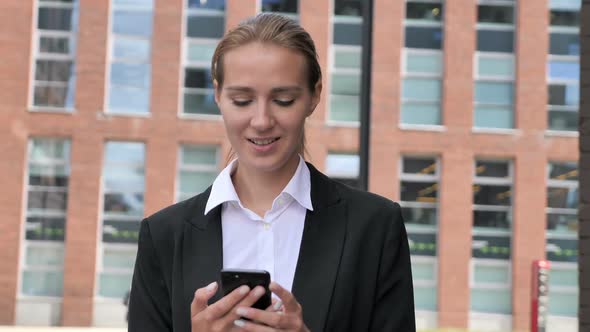 Woman Walking and Using Smartphone