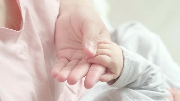 Newborn Baby Hand Holding Mother Mom Touching Baby Tiny Hand to Make Him Feeling Her Love Warm and