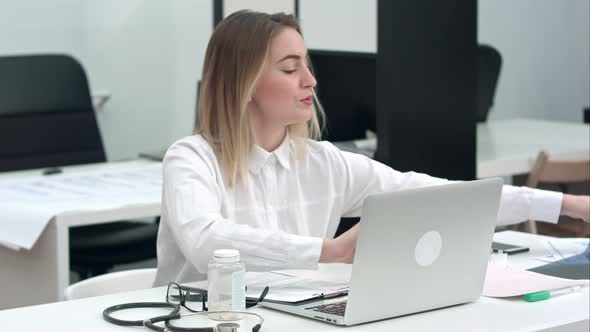 Female Doctor Examining Xray Image Sitting in the Office