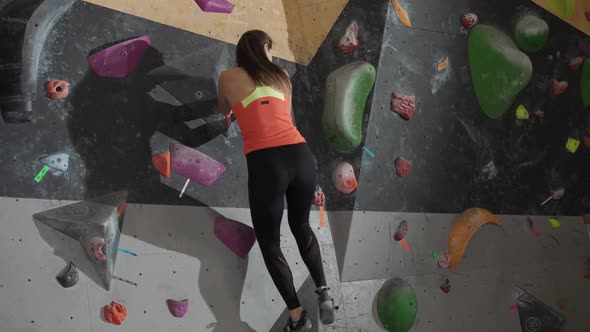 Female Climber Training on a Climbing Wall Young Woman Practicing Rockclimbing Mountaineer Training