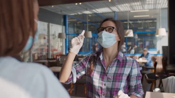 Customer in Face Mask and Gloves Giving Order To Waitress at Counter in Cafeteria