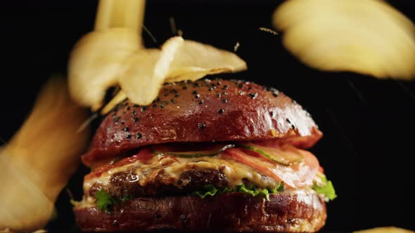 Tasty Burger and Falling Chips Closeup Cooked Juicy Sandwich Fast Food Concept Recipe of Preparing