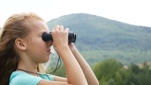 Girl on the Background of the Mountains Looking into the Distance. Slow Motion