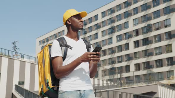 Handsome Black African American Food Delivery Courier Posing in Front of Camera