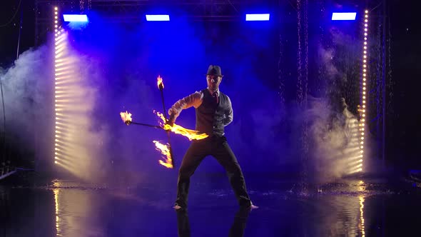 Fireshow Performance with Burning Torch Performed By a Man in a Suit and Hat. Fire Show in the Rain