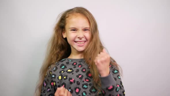 Funny Preteen Girl 10-11 Years Old Clenching Fists Like Winner. Dancing Excited by Success