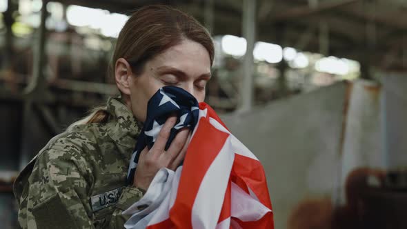 Female Soldier Feeling Proud While Kissing American Flag