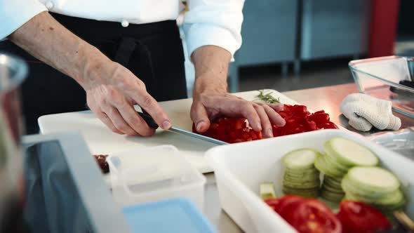 Close-up: The chef adds chopped peppers to the pot. The process of preparing food in a restaurant.