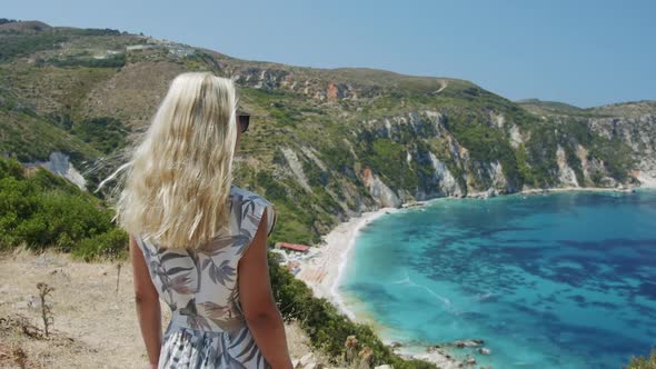 Blond Woman Traveller on Top of Mountain Looking at Beautiful Sea Bay Celebrating Scenic Landscape