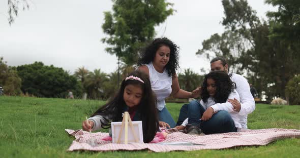 Indian parents having fun at city park painting with their children