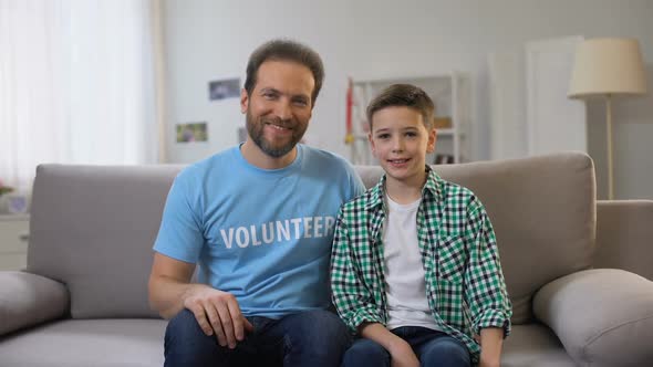 Smiling Middle-Aged Volunteer and Schoolboy Shoving Thumbs-Up to Camera, Ad