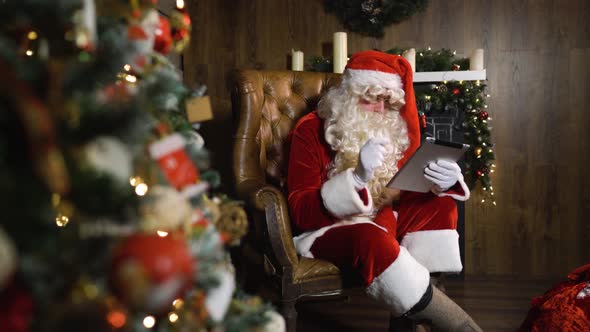 Santa Claus Working with Digital Pad TabletPC