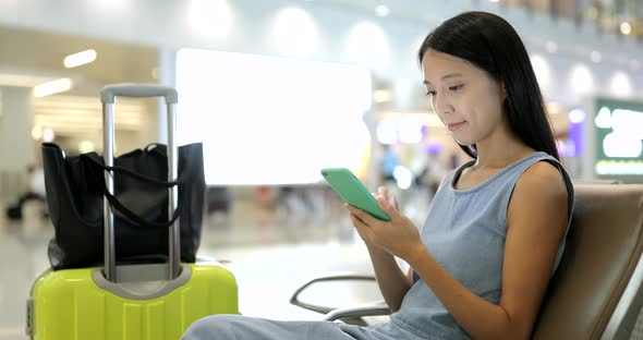 Woman use of cellphone in airport of Hong Kong 