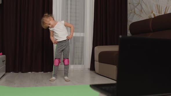 Little Children Girl Watching Online Distance Lessons with Trainer on Laptop Exercising at Home