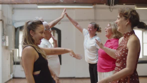 People Standing Against Each Other in Ballroom and Giving Five