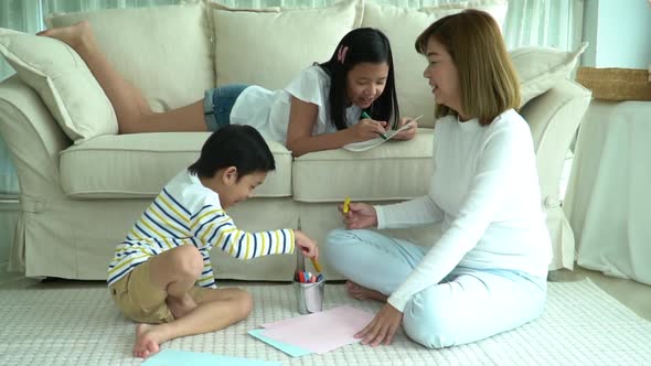 Asian Family Drawing Together In Living Room