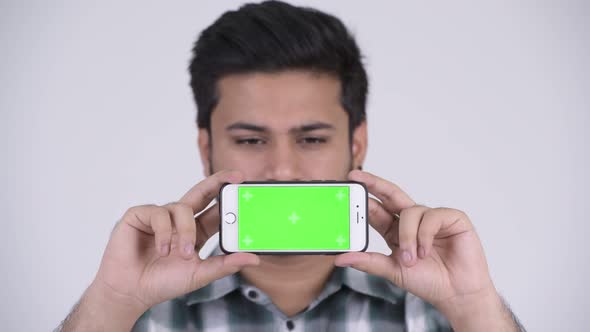 Young Happy Bearded Indian Man Smiling While Showing Phone