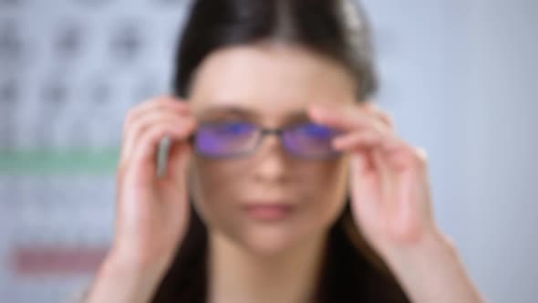 Lady Patient With Refocused Vision Putting on New Glasses and Smiling to Camera