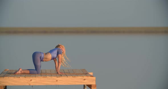 Stretching and Yoga in the Middle of the Lake on a Platform Woman is Exercising