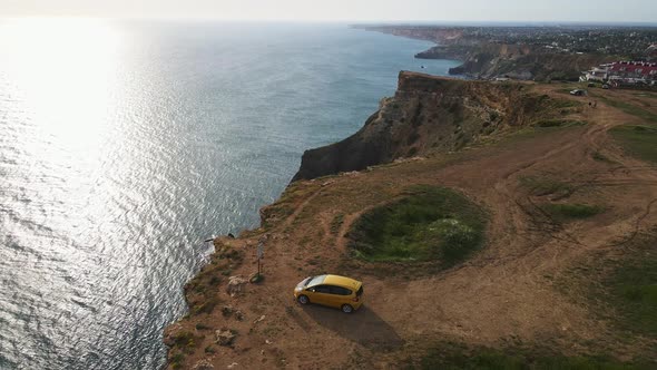 A Yellow Car Stands on the Edge of a Cliff at Cape Lermontov