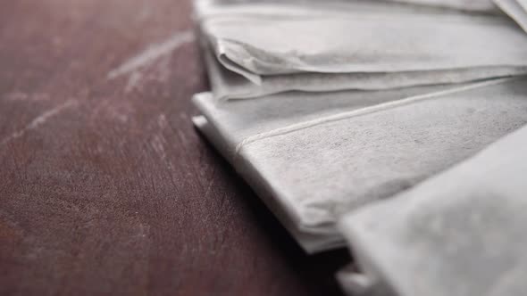 Paper bags with herbal tea on a old rustic wooden table. Macro