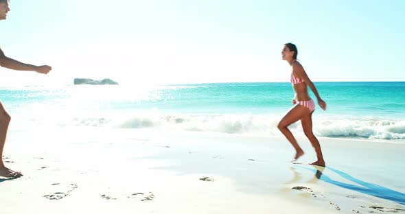 Couple performing somersault on beach