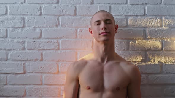 Sunrays on a Handsome Bald Shirtless Adult Gay Man Posing in Font of White Wall