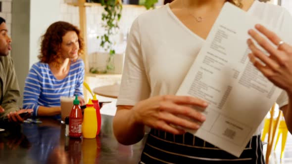 Portrait of beautiful waitress holding menu card 4k