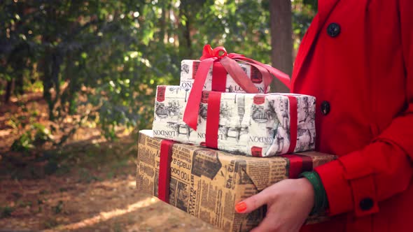 Wrapped Gifts. Close Up. Woman Holding Several Beautifully Packed Boxes in Her Hands. Outdoors