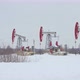 Four oil rockers work in winter on a snow-covered field against a forest background - VideoHive Item for Sale
