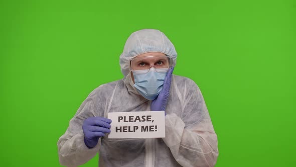 Doctor in PPE Suit with Text Inscription  Please Help Me n Chroma Key Coronavirus Pandemic