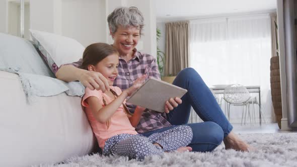 Senior woman using digital tablet with her granddaughter