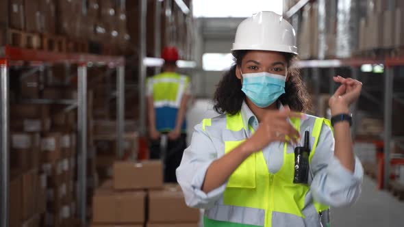 Masked Mixed Race Woman Worker Posing in Warehouse