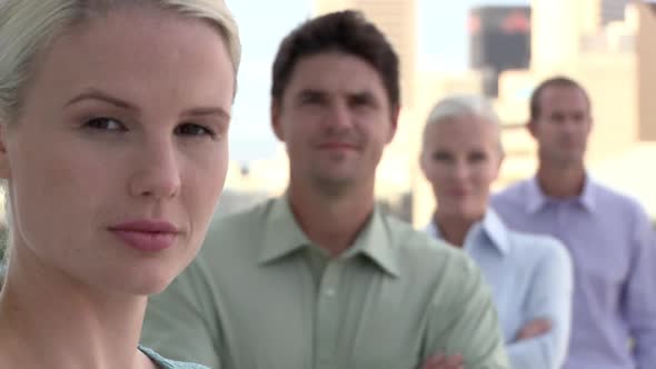 Four businesspeople in a row, looking at camera