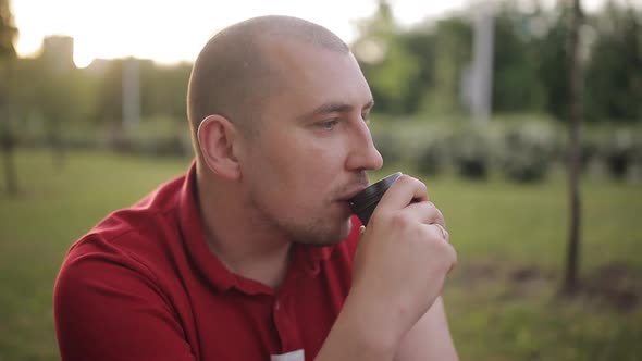 Man Drinking Coffee Outdoors at Sunset