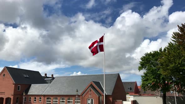 Denmark flag swaying in the wind on the big pole. Taken in Esbjerg, Denmark.