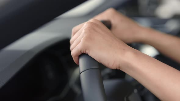 Close Up of Steering Wheel with Female Hands on It